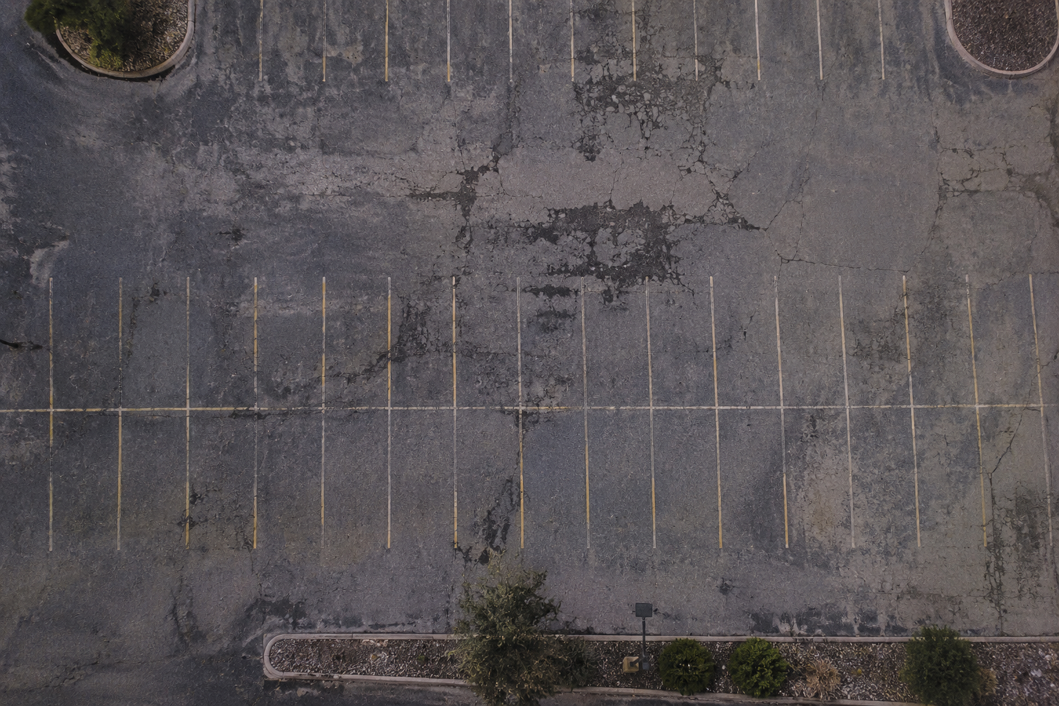Faded, worn-out parking lot before striping
